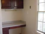 The kitchen cabinetry includes a handy desk with drawers and has room for a small table.