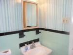 This is the sink side of the bath on the main floor with its pretty wall paper above the soft green tile.