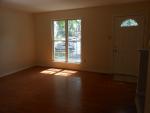 The living room has pretty hardwood floors and a large window.